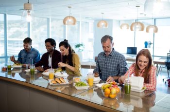 офісні працівники разом обідають у їдальні