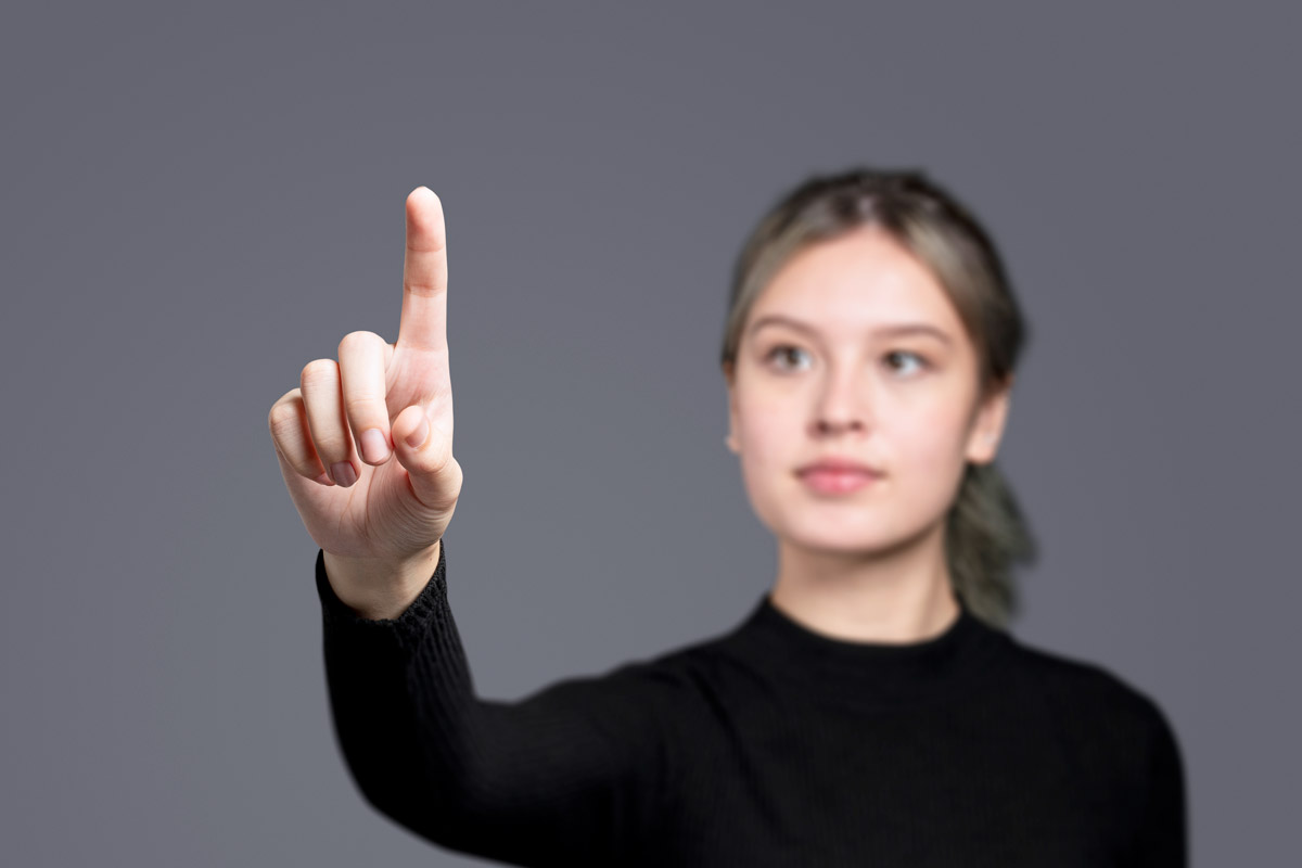 дівчина робить вправи для покращення зору, витягнувши руку вперед із піднятим вказівним пальцем
