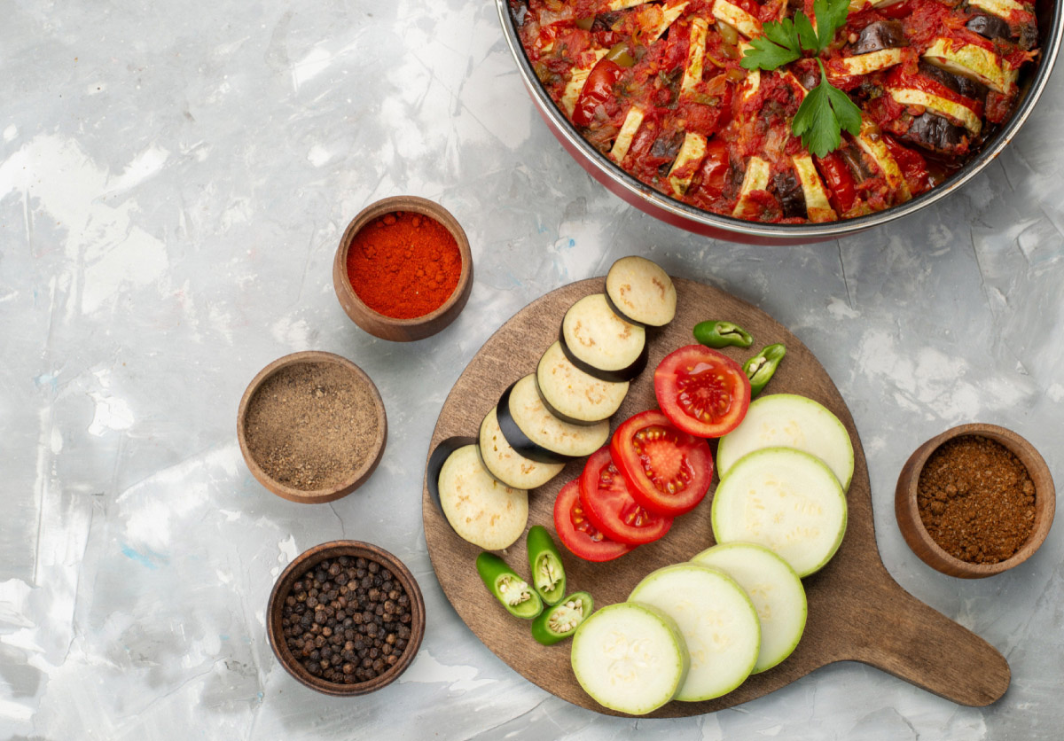 овочі для рататуя по-домашньому, порізані кружальцями на дощечці