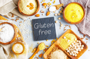 табличка англійською без глютену на фоні із зображенням різноманітних злаків та видів борошна