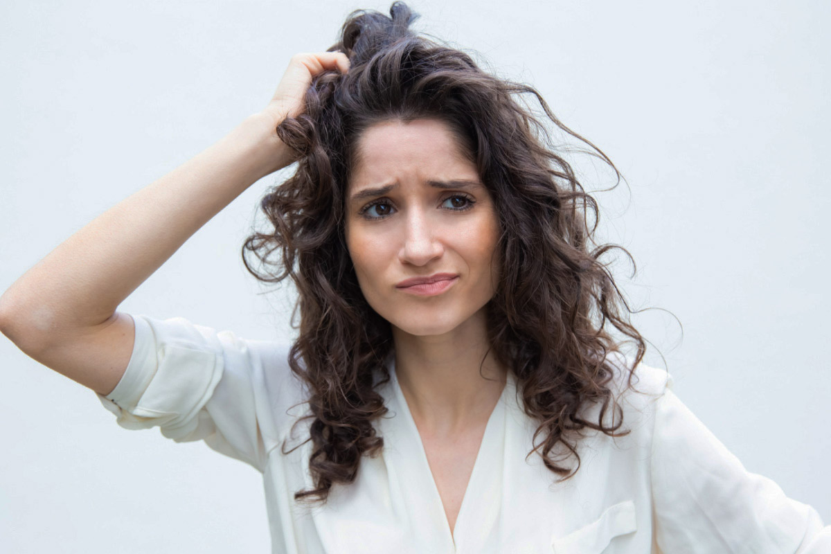 жінка виглядає схвильованою станом свого волосся