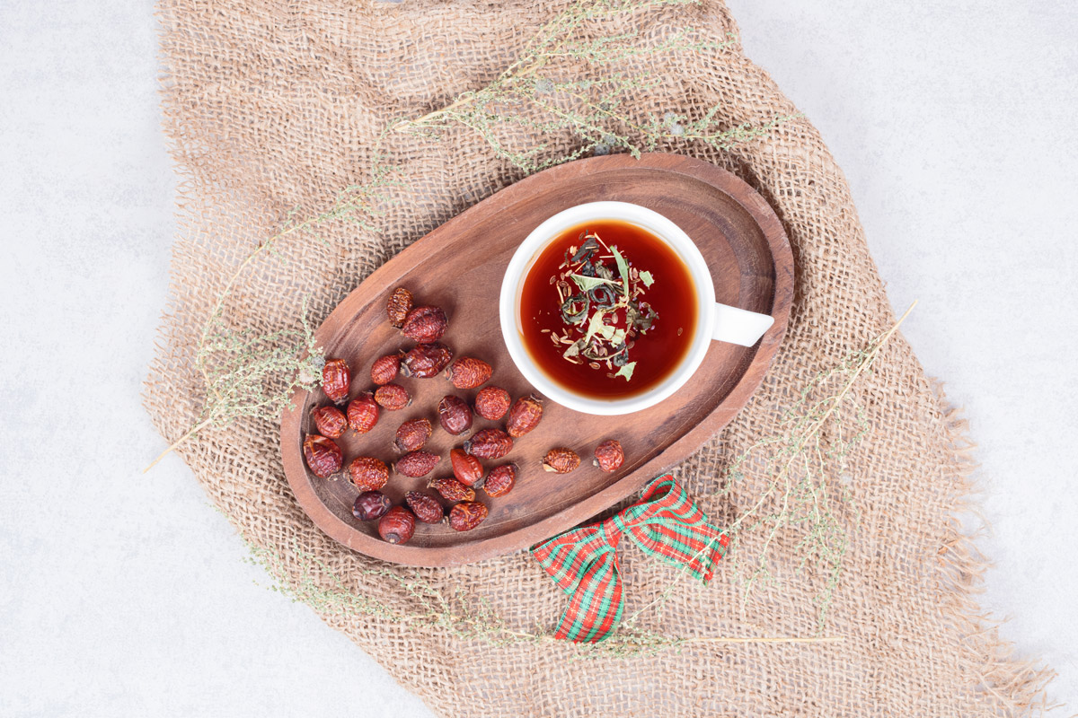 зображена чашка чаю на таці, яка стоїть разом із сушеною журавлиною