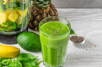 склянка із готовим смузі зеленого кольору, а також зображення лайму та цитрусових