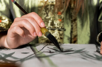 жінка малює аквареллю пухнастим пензликам для малювання