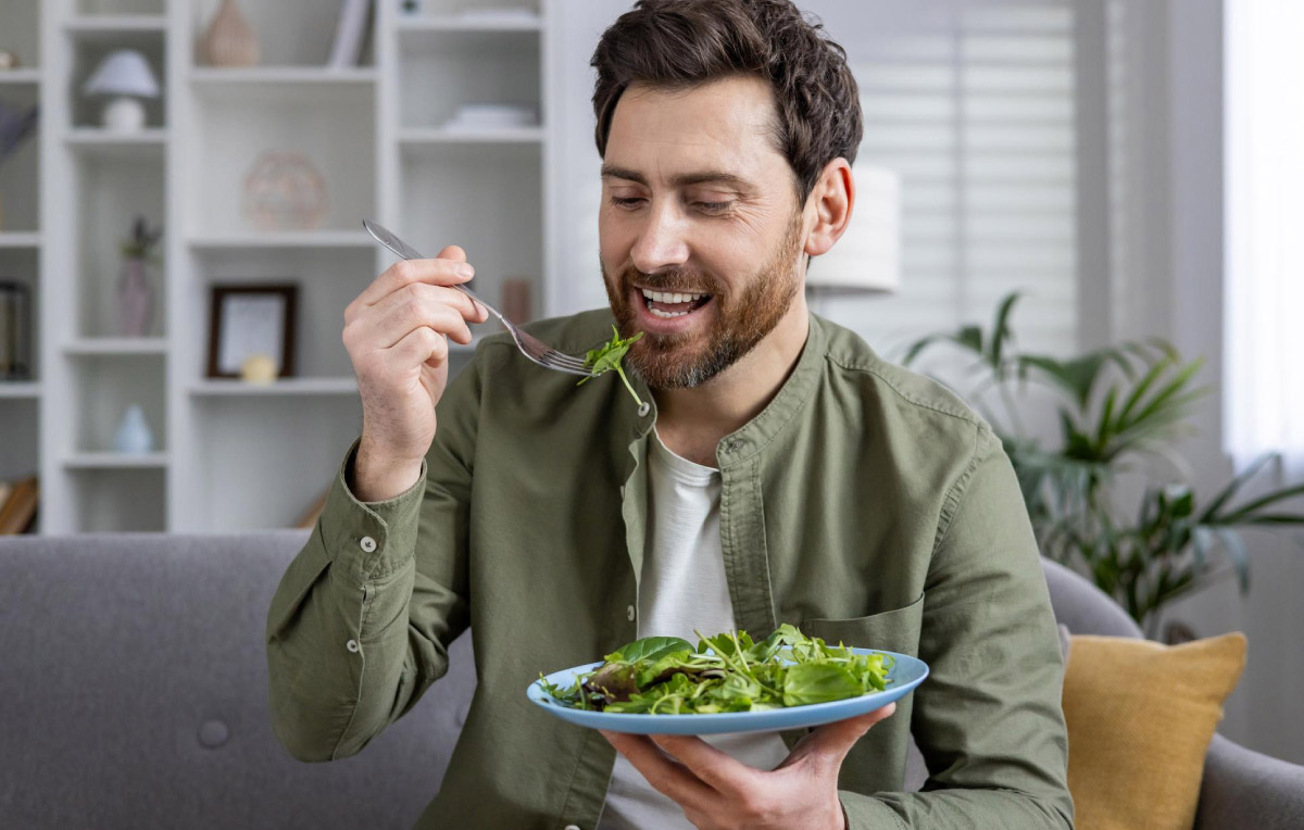 чоловік куштує зелень, викладену на тарілці