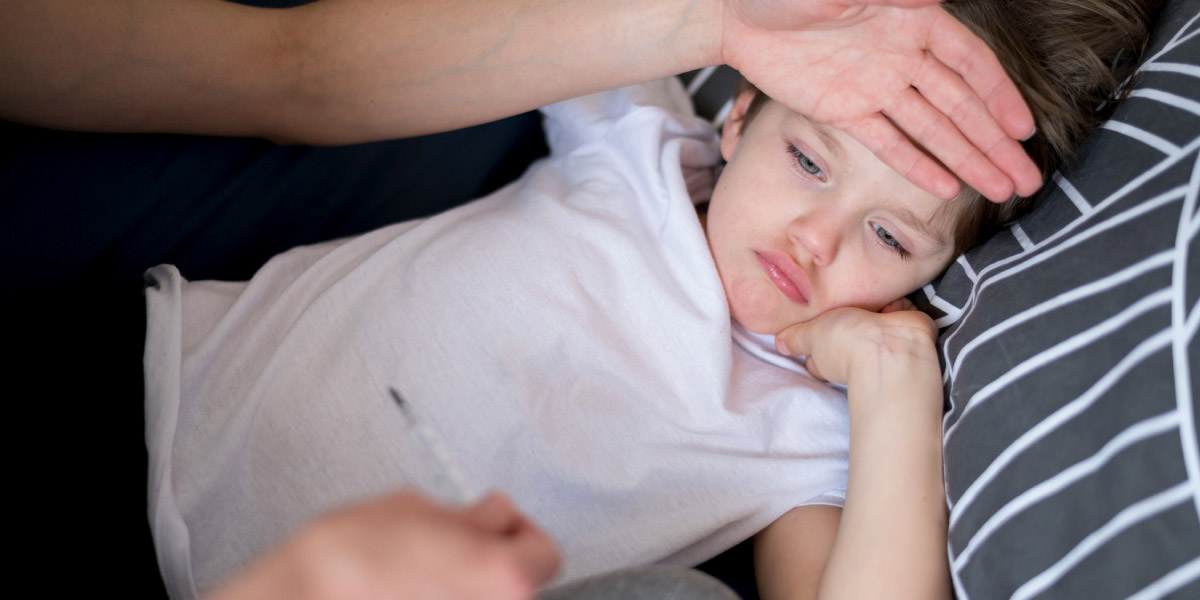 хворий хлопчик лежить вдома, і хтось із батьків перевіряє йому температуру шляхом дотику долонею до лоба