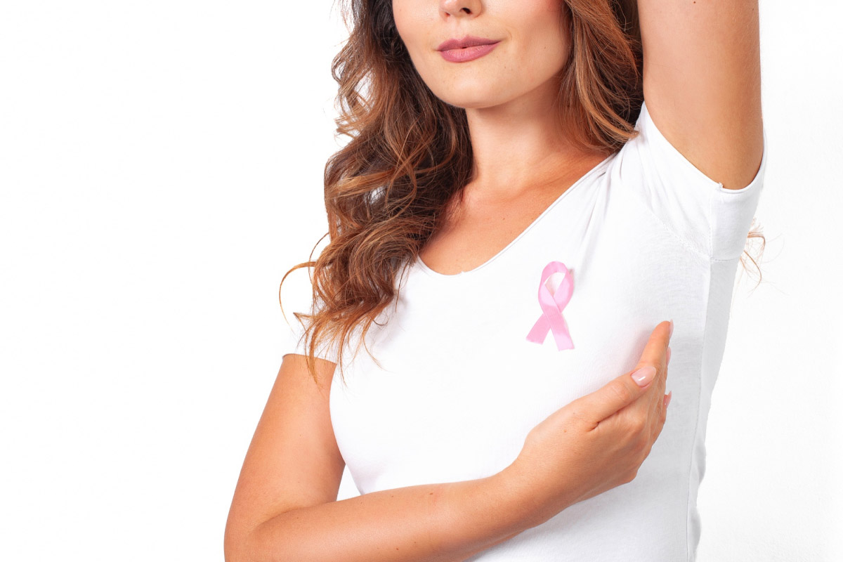 жінка показує як правильно оглядати молочну залозу