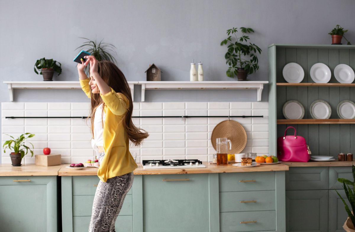 жінка радісно танцює на кухні