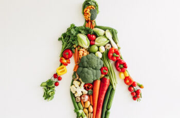 фігура людини, викладена різнобарвними овочами та зеленню