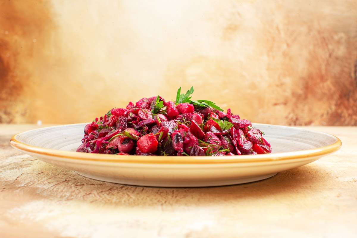 на тарілці салат із червоного буряка із зеленню