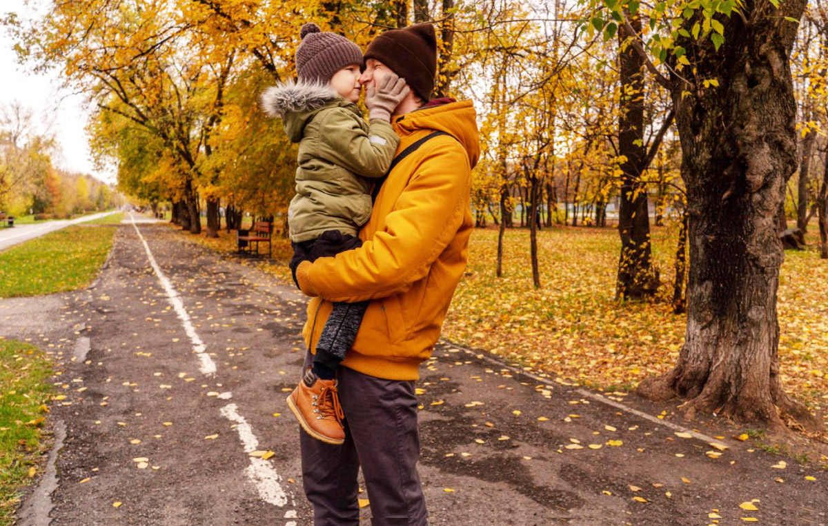 тато із сином на прогулянці восени в парку, де дерева вбрані в золотисте листя