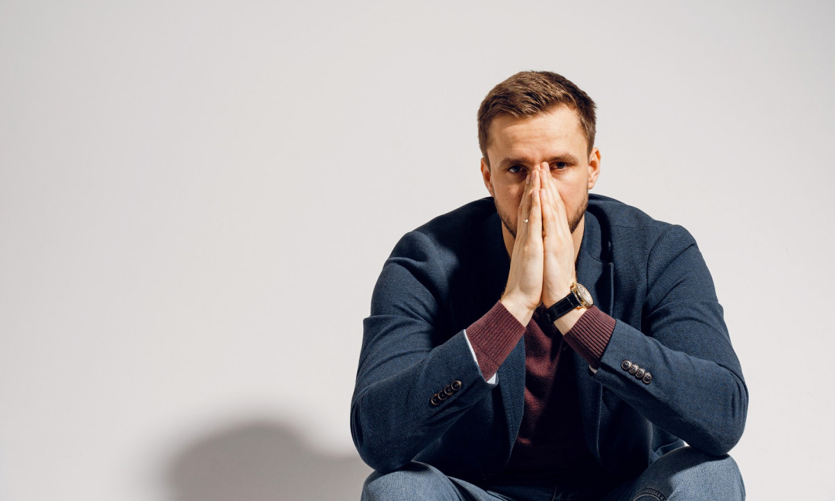 засмучений та задумливий чоловік сидить