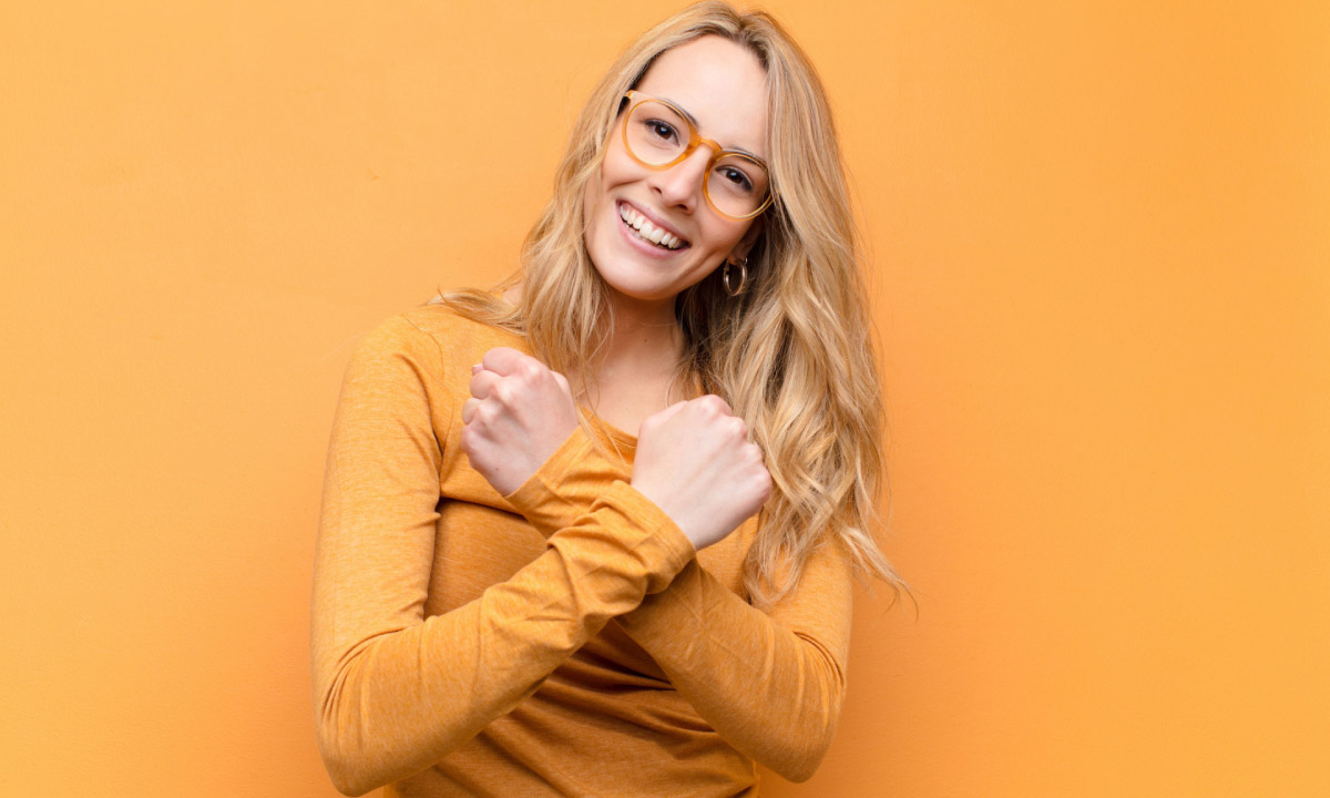 жінка на жовтому фоні посміхається доброзичливо