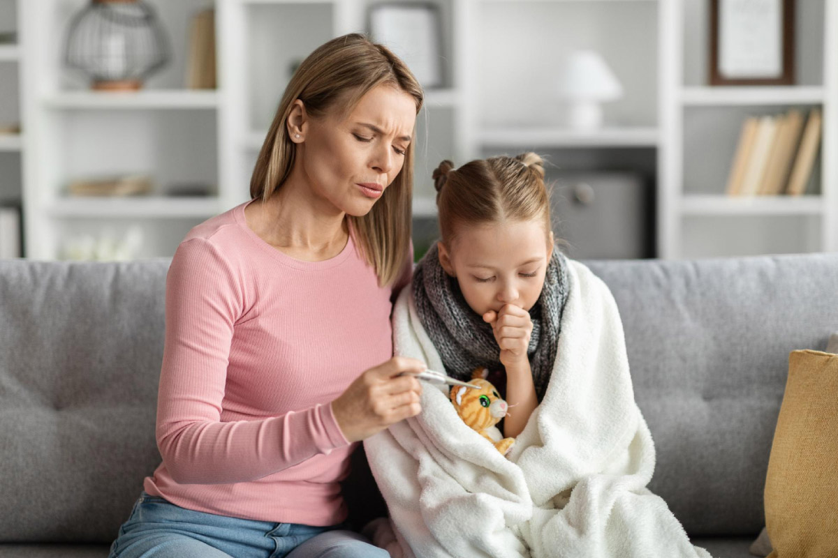 жінка перевіряє температуру своїй дитині