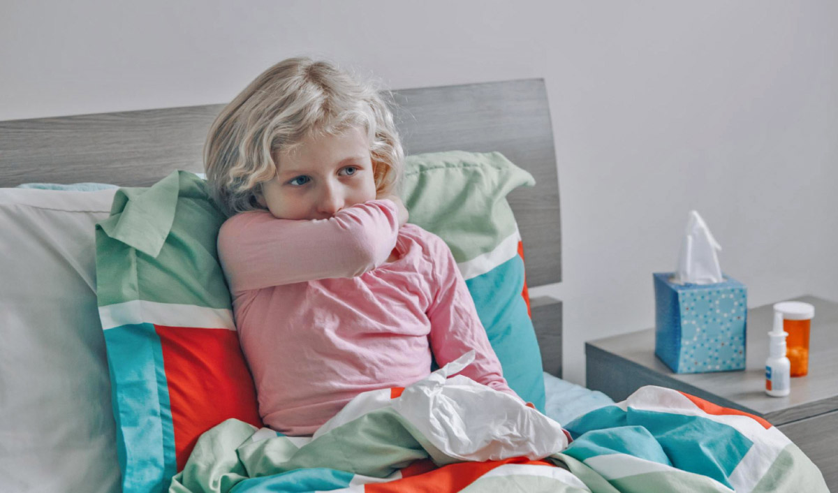 дівчинка хворіє на трахеїт вдома у ліжку