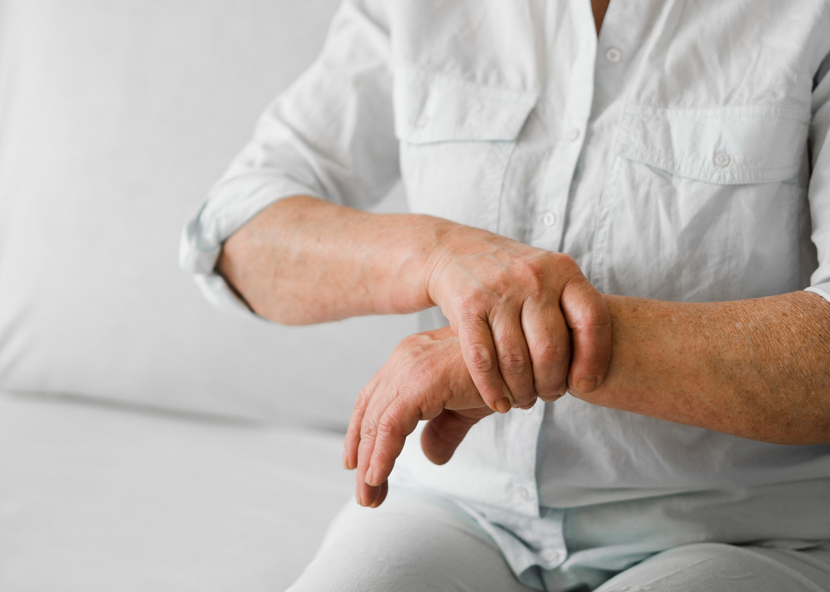 біль суглобів - людина тримається за зап'ястя