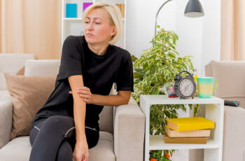 жінка відчуває біль у суглобі ліктя через бурсит