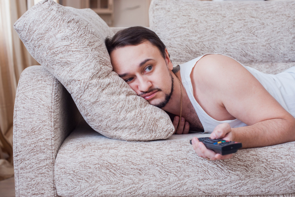 чоловік почувається погано та лежить на дивані