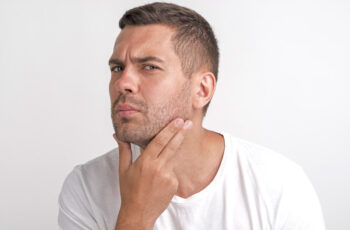 чоловік придивляється до свого обличчя