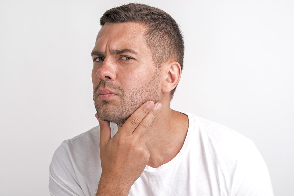 чоловік придивляється до свого обличчя