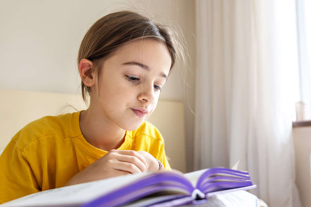 дівчинка читає книгу