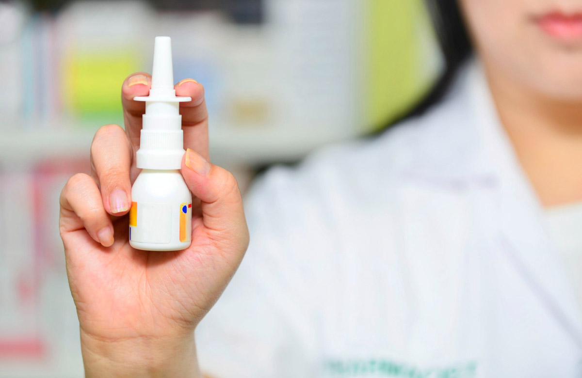 фармацевт тримає спрей для носа в руці