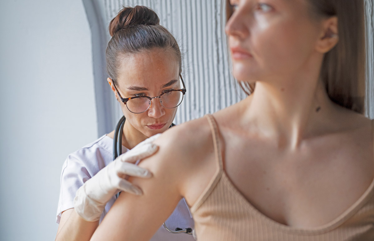 лікар оглядає шкіру пацієнта