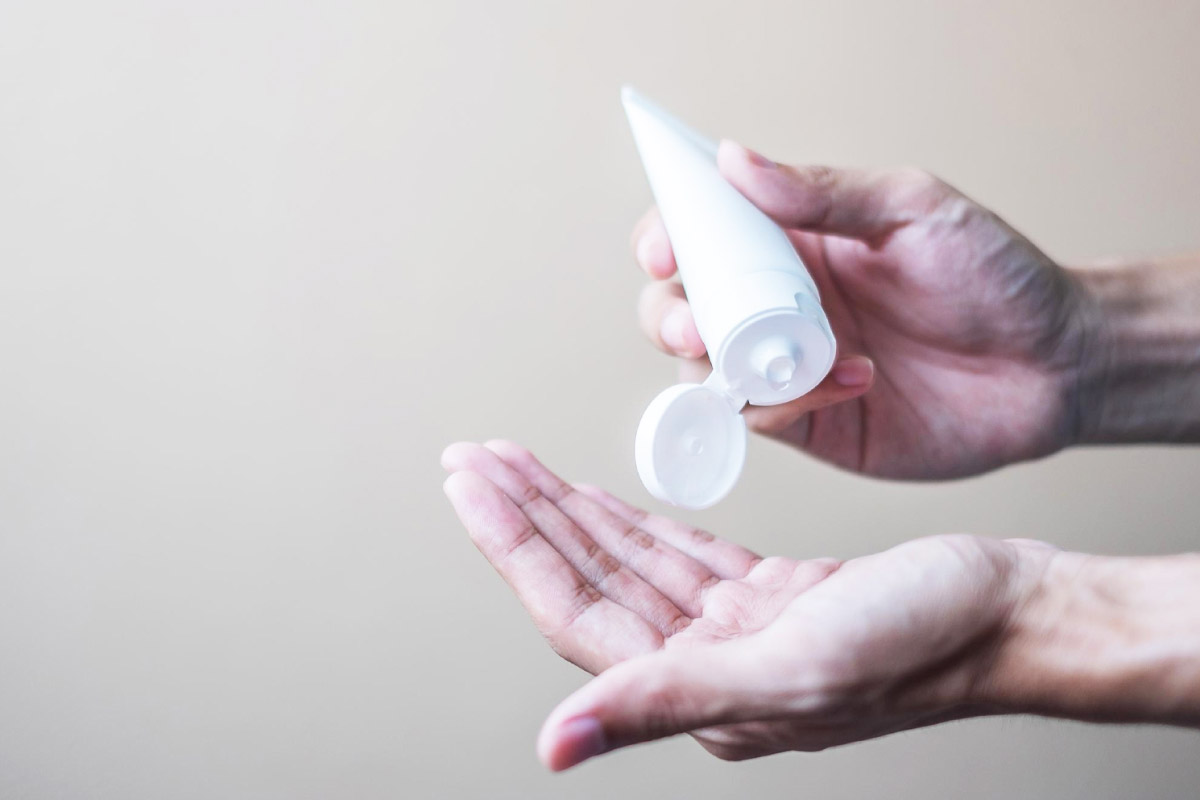 людина тримає в руках крем для рук