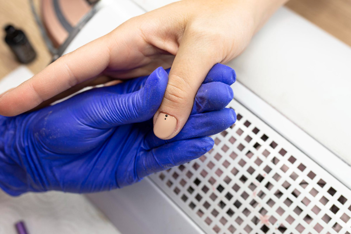 майстер манікюру робить клієнту манікюр