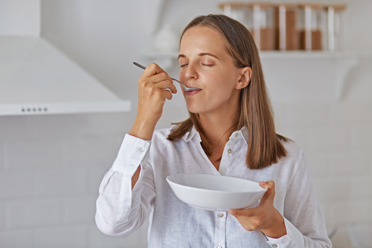 молода мама їсть суп