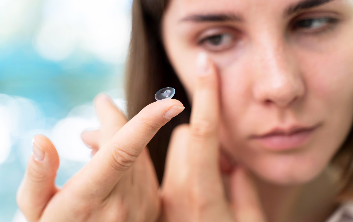 жінка надягає лінзи для очей