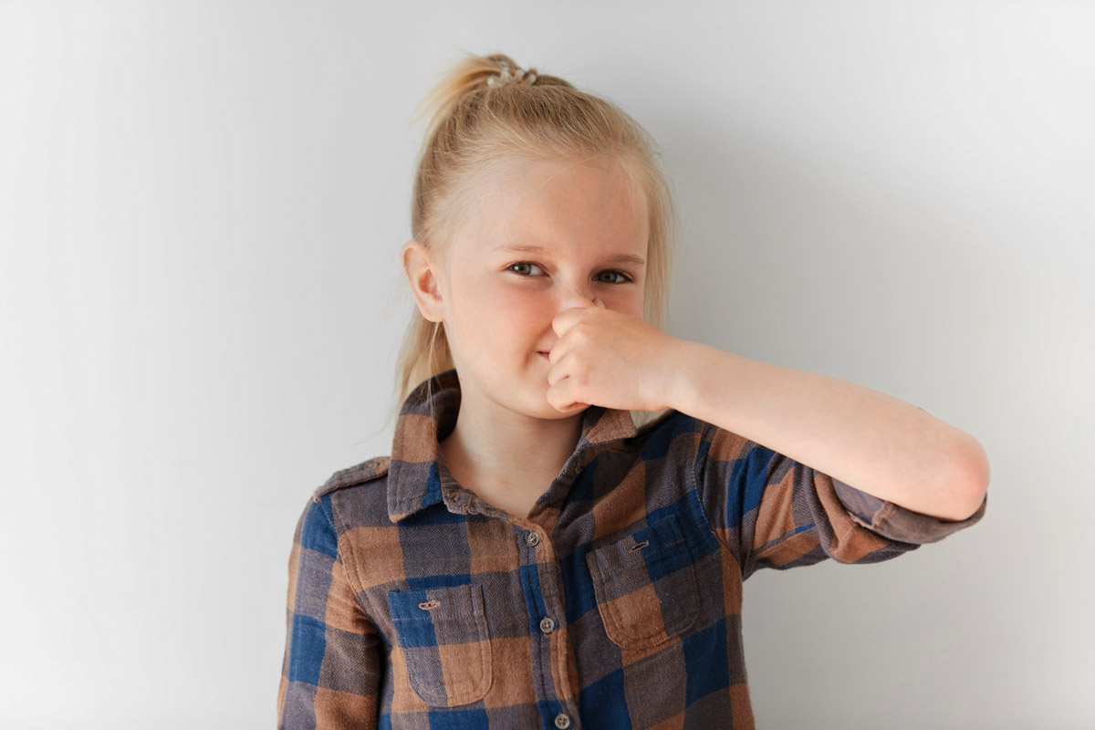 дівчинка затуляє носа рукою