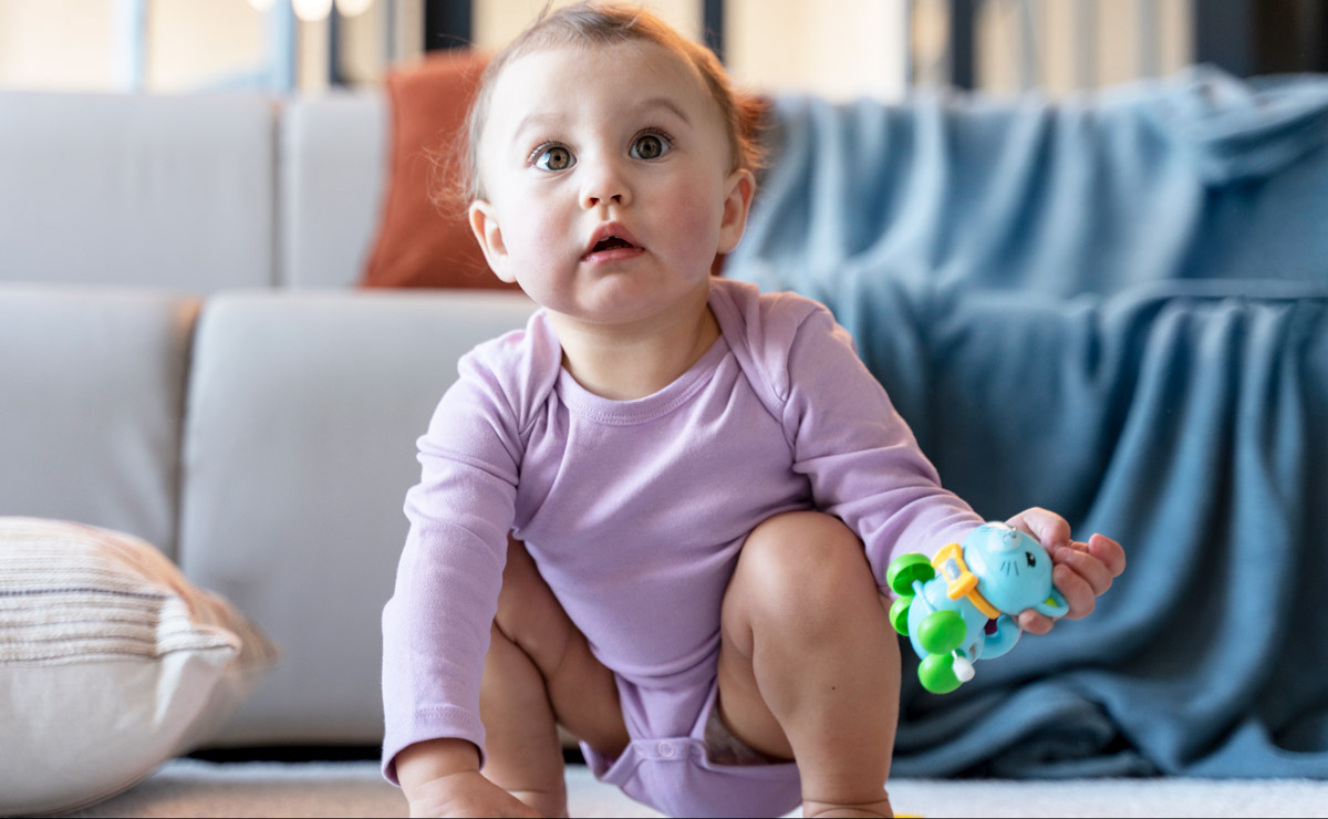 дитинка грається своїми іграшками