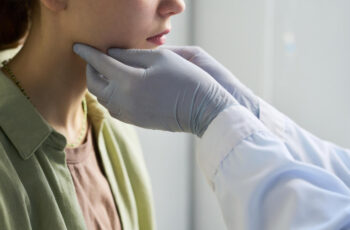 лікар проводить пальпацію лімфовузлів шиї пацієнтки