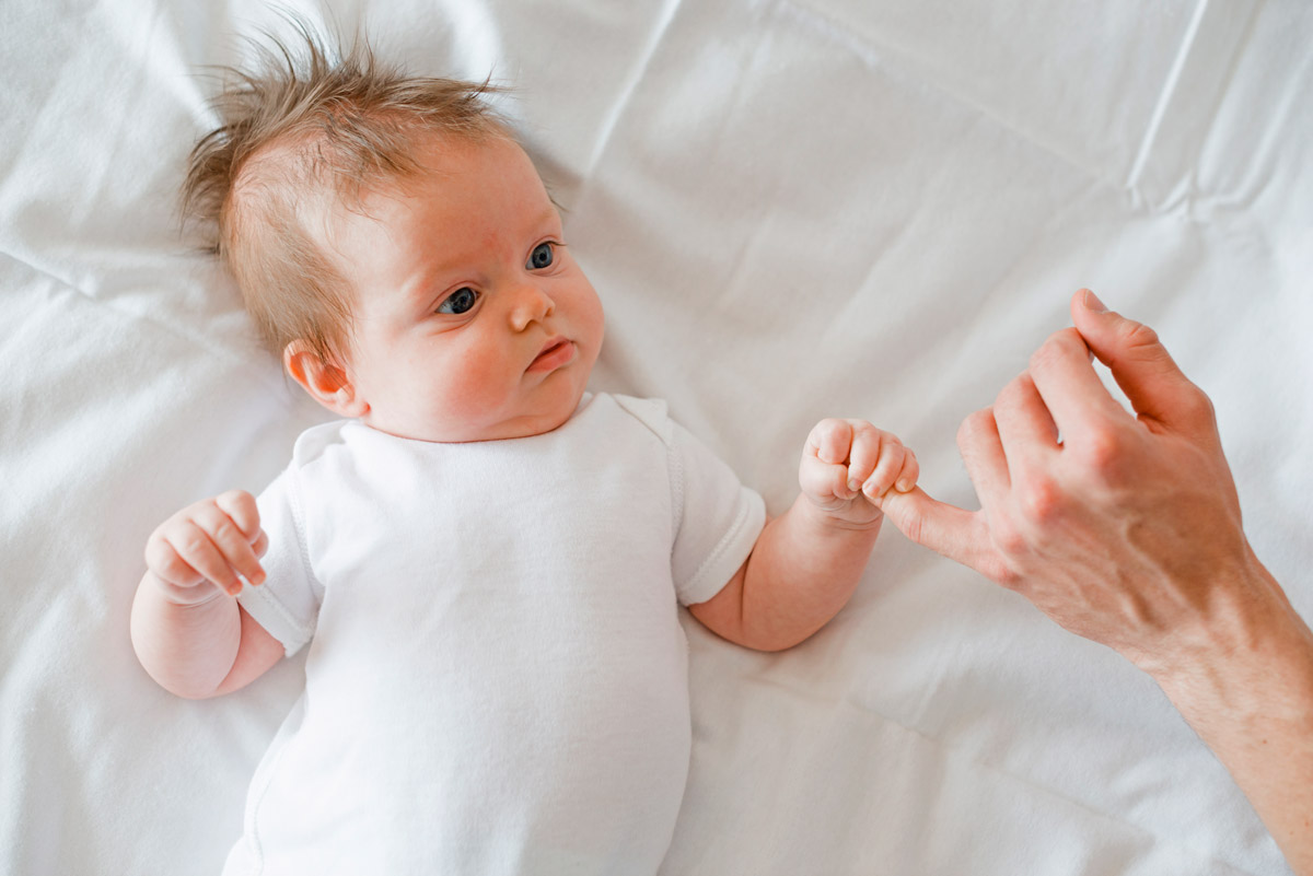 мама тримає новонароджену дитину за ручку