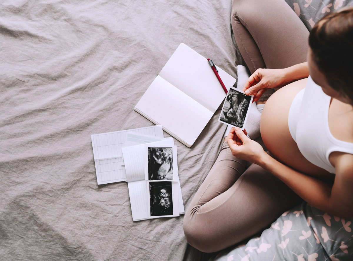 вагітна жінка тримає зображення, зроблене під час УЗД