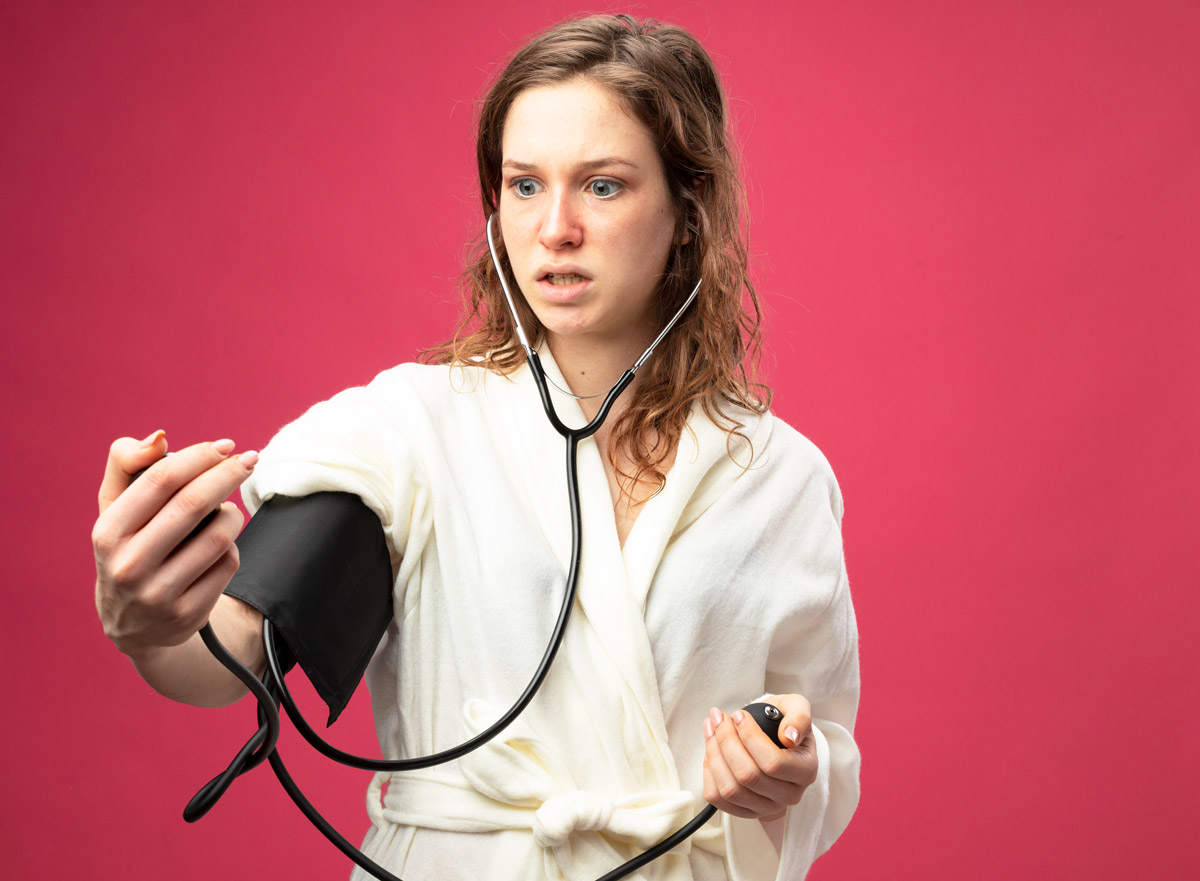 жінка вимірює собі тиск за допомогою тонометра